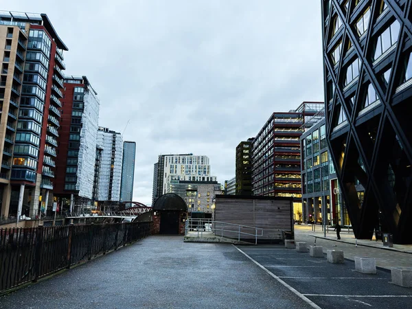 Manchester, İngiltere - 21 Ocak 2026: Çağdaş kuleler ve ayırt edici mimarinin yer aldığı Manchester nehir kıyısı boyunca bir şehir manzarası.