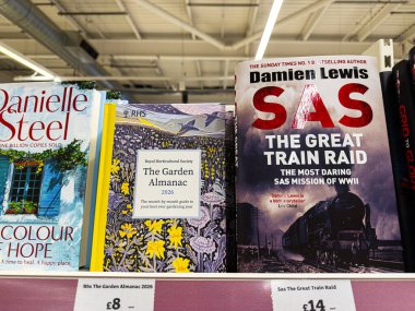 Manchester, İngiltere - 21 Ocak 2026: Bir mağaza rafında çeşitli türler ve göz alıcı kapakları sergilenen bir dizi kitap