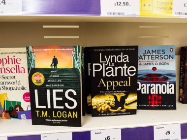 Manchester, İngiltere - 21 Ocak 2026: Renkli modern kitap kapakları gerilim ve en çok satanların yer aldığı bir mağaza rafında.