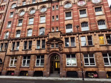 Manchester, İngiltere - 22 Ocak 2026: Manchester 'da kemerli camlar, dekoratif taş işçiliği ve görkemli bir girişi olan tarihi bir Lancaster Binası.