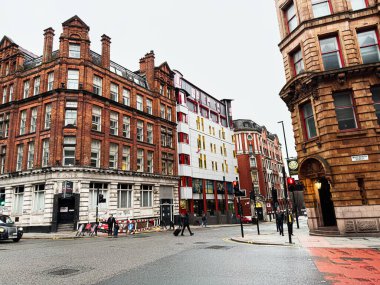 Manchester, İngiltere - 22 Ocak 2026: Manchester Whitworth Caddesi 'nde bulutlu bir gökyüzü altında kırmızı tuğlalar ve beyaz modern binalar.