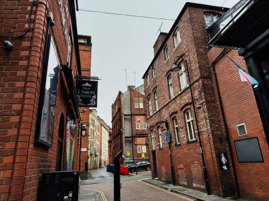 Manchester, İngiltere - 22 Ocak 2026: Manchester 'daki dar tuğla sokak eski Marston binaları ve şehir cazibesiyle doluydu.