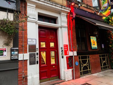 Manchester, İngiltere - 22 Ocak 2026: Parlak kanal mahkemesi kırmızı kapıları, tuğla cephesi ve kentsel tabelaların yer aldığı Manchester caddesi sahnesi.