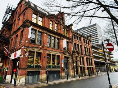 Manchester, İngiltere - 22 Ocak 2026: Manchester 'daki Chorlton caddesindeki tarihi tuğla bina, eski mimariyle modern ufuk çizgisini harmanlıyor.