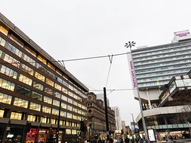 Manchester, İngiltere - 22 Ocak 2026: Manchester 'da şehir caddesi modern mimari, tramvay kabloları ve önde gelen Mercure Hotel' i gösteriyor.