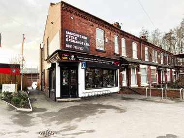 Manchester, İngiltere - 23 Ocak 2026: Manchester 'daki tuğla mağazası sakin bir caddede bisiklet ve vitrinli bisiklet dükkanı sunuyor.