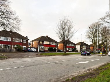 Manchester, İngiltere - 23 Ocak 2026: Manchester, İngiltere 'de sakin bir banliyö, tuğladan evler, park edilmiş arabalar ve yerleşim yeri caddesi boyunca çıplak ağaçlar.