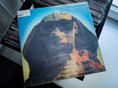 Lviv, Ukrayna - 07 Şubat 2026: Renkli vinil KISS, 1989 Gölgesi Altında Güneş gözlüklü bir portre ile retro ve sürrealist elementlerin harmanlanması.