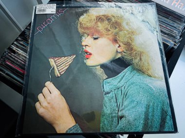 Lviv, Ukrayna - 07 Şubat 2026: Pastanın tadına bakan bir kadının klasik tarzı portresi, parlak bir Pire 1977 albüm kapağında yer alıyor.