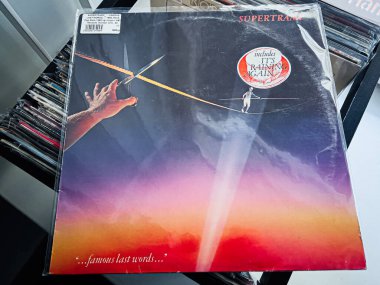 Lviv, Ukrayna - 07 Şubat 2026: Klasik Supertramp, Meşhur Son Sözler 1982 Günbatımı gradyanı ile kaplanmış vinil, karanlık bir gökyüzünde ip kesen bir el dramatik retro ruh halini çağrıştırıyor..