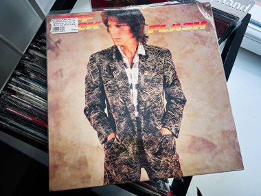 Lviv, Ukrayna - 07 Şubat 2026: Vintage Jeff Beck, Flash vinil kılıfı, 1980 'lerin rock enerjisini yakalayan cesur desenli takım elbiseli bir adam.