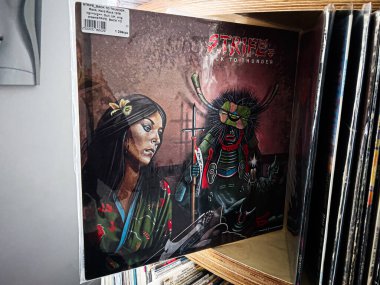 Lviv, Ukrayna - 07 Şubat 2026: Strife, Back to Thunder 'dan canlı vinil kapak resmi, karanlık bir sahnede maskeli, şeytani bir figürün yanında yer alan bir kadın.