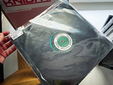 Lviv, Ukrayna - 07 Şubat 2026: Ahşap bir rafta yeşil dairesel etiketli siyah vinil, klasik müzik koleksiyonu. Poltering Ritim, Traxx