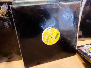 Lviv, Ukrayna - 07 Şubat 2026: Bir mağaza rafında parlak sarı dairesel etiketli siyah bir vinil kolun yakın çekimi. Locktown ve Alexandra Prince yaşıyor..