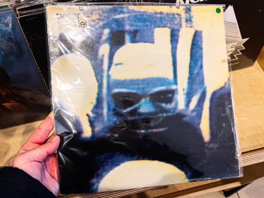 Lviv, Ukrayna - 7 Şubat 2026: Peter Gabriel 1982 kapağında soyut mavi maskeli yüz; karamsar, sanatsal ve sıcak ışık titreşimli retro-atmosfer.