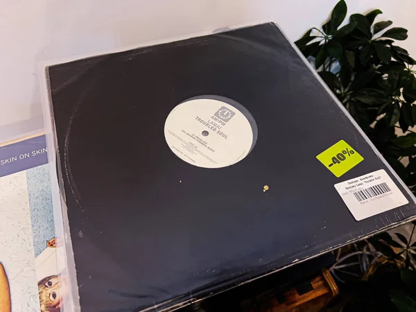 Lviv, Ukrayna - 7 Şubat 2026: Vinil Lamai Troubled Soul kaydı arkaplanda kalın bir indirim etiketi ve bitkiyle sergileniyor.