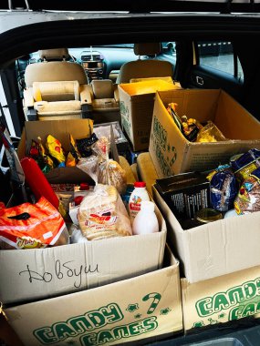 Lviv, Ukrayna - 07 Şubat 2026: Aile gezisi veya taşınma için kutu, çanta ve bakkaliye dolu bir araba bagajı.