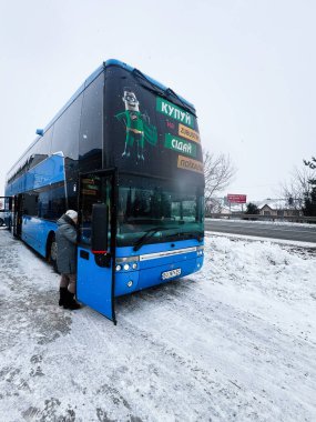 Lviv, Ukrayna - 07 Şubat 2026: Mavi çift katlı otobüs karlı bir alanda yolcu olarak bekliyor.