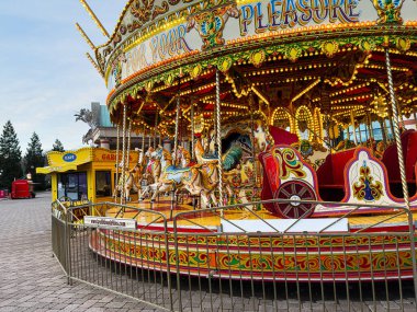 Manchester, İngiltere - 23 Ocak 2026: Süslü atlar ve Manchester 'da canlı bir açık hava fuarında parlayan ışıklar eşliğinde renkli bir atlıkarınca dolaşır