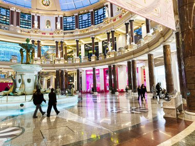 Manchester, İngiltere - 23 Ocak 2026: Büyük bir fıskiye, mermer zemin ve müşterilerin yer aldığı büyük bir perakende mağazasının işlek Trafford Palazzo iç mekanı.