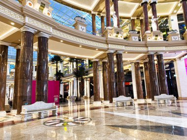 Manchester, İngiltere - 23 Ocak 2026: Uzun mermer sütunları, cilalı zemini ve Trafford Palazzo 'daki dekoratif bankları olan zarif bir avlu..