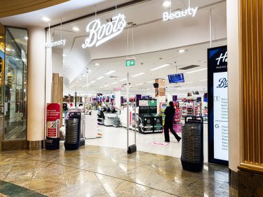 Manchester, İngiltere - 23 Ocak 2026: Müşteriler Trafford Center 'daki parlak ışıklandırılmış Boots mağazasında kozmetik ve güzellik ürünlerine göz atıyorlar.