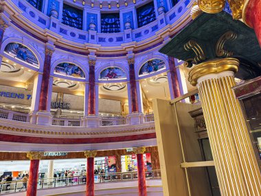 Manchester, İngiltere - 23 Ocak 2026: Manchester, Manchester 'daki The Trafford Centre' da lüks alışveriş merkezi, mor mavi ışıklandırma, büyük kemerler, mermer sütunlar ve müşteriler.