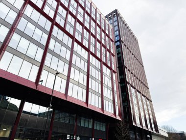Manchester, İngiltere - 24 Ocak 2026: Manchester 'daki Circle Square kırmızı çerçeveli ofis binası, kentsel mimari ve yansıtıcı perdeler sergileniyor.