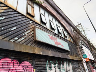 Manchester, İngiltere - 24 Ocak 2026: Manchester 'daki şehir harabesi graffiti, Whim Wham Cafe yaşlanma tabelası ve yıpranmış metal mağazası.