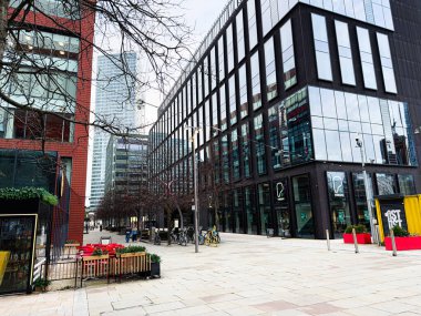 Manchester, İngiltere - 24 Ocak 2026: Manchester 'ın ilk kentsel sahnesi cam safkan spor salonu cepheleri, bisikletler ve açık bir plazanın yer aldığı.