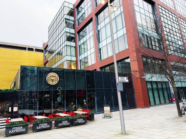 Manchester, İngiltere - 24 Ocak 2026: Manchester 'da pizza ekspresi, kırmızı sandalyeler ve cam mağazaları olan şehir restoranı.