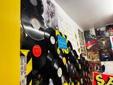 Manchester, İngiltere - 26 Ocak 2026: Vinil kayıtları Manchester 'daki bir mağazanın duvarlarını kaplıyor, posterler ve renkli müzik dekorlarıyla çevrili..