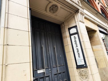 Manchester, İngiltere - 26 Ocak 2026: Karanlık ahşap kapılar Manchester, İngiltere 'de tarihi bir pazar binası girişini çerçeveledi.