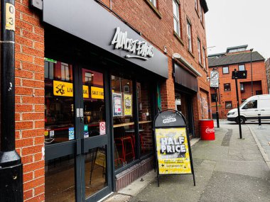 Manchester, İngiltere - 26 Ocak 2026: Brick Manchester 'da neredeyse ünlü mağaza önü yarı fiyatına satış, sarı tabela ve sokak manzarası reklamları.