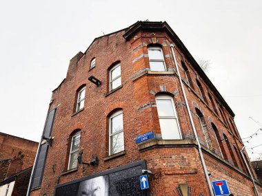 Manchester, İngiltere - 26 Ocak 2026: Manchester 'daki Carpenters Lane' de kemerli camları ve klasik mimarisi olan kırmızı tuğlalı bir bina.