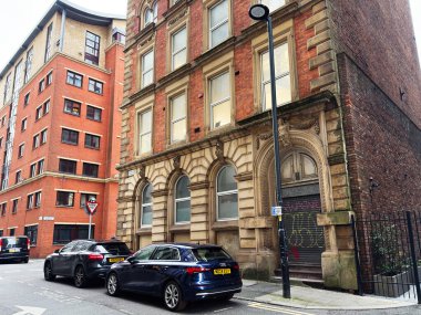 Manchester, İngiltere - 29 Ocak 2026: Manchester 'daki City George caddesi süslü bir kapı aralığı, kırmızı tuğla cephe ve modern park edilmiş arabalar içeriyor.