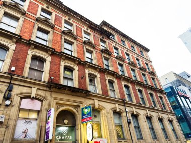 Manchester, İngiltere - 29 Ocak 2026: Manchester 'daki zemin kat mağazaları ve şehir caddesi boyunca klasik mimarisi olan Terraced Manchester binası.