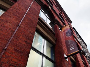 Manchester, İngiltere - 29 Ocak 2026: Manchester 'da dikey Clarence House pankart süitleri olan kırmızı tuğlalı bir cephenin dış görünümü.