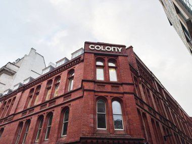 Manchester, İngiltere - 29 Ocak 2026: Kemerli camlı tarihi kırmızı tuğla cephe ve Manchester 'daki Koloni Çalışma Alanı tabelası.