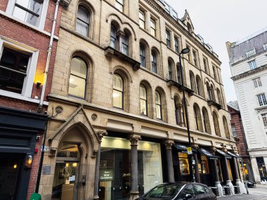 Manchester, İngiltere - 29 Ocak 2026: Kemerli Bow Chambers pencereleri ve vitrinleriyle Manchester tarihi caddesi, Birleşik Krallık 'ta gündüz kentsel manzarası.