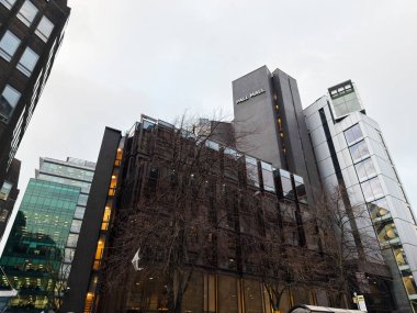 Manchester, İngiltere - 29 Ocak 2026: Manchester 'da cam cepheli ve yapraksız ağaçlı bir dizi Pall Mall ofis binası.