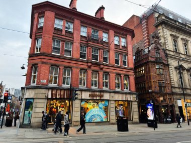 Manchester, İngiltere - 29 Ocak 2026: Manchester şehir merkezi caddesi kırmızı tuğla bina, yayalar ve aktif Patagonya mağazaları ile dolu.
