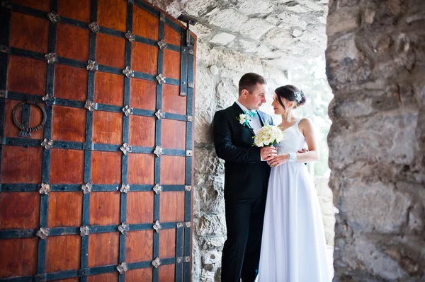 Appena sposati nel giorno del loro matrimonio vicino al vecchio cancello di legno — Foto Stock