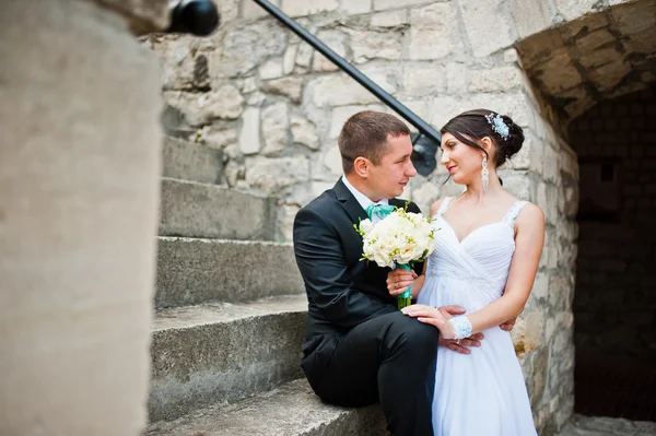 Recién casados en el día de su boda cerca de la vieja puerta de madera — Foto de Stock