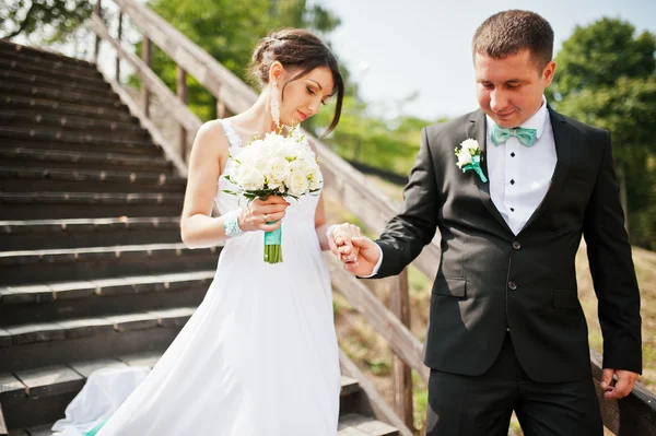 Pareja de boda en escaleras de madera — Foto de Stock