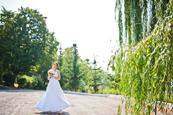 Brunette mariée près de saule avec bouquet de mariage — Photo
