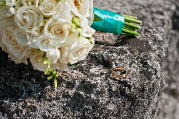 Bröllop bukett med ringar på sten — Stockfoto