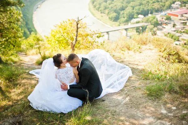Pareja de boda en panorama de la ciudad y el río. novia con largo ve — Foto de Stock