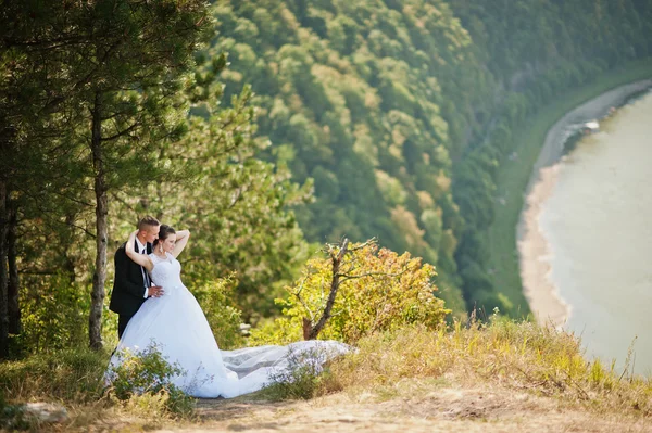 Casal de casamento no panorama da cidade e do rio. noiva com longa ve — Fotografia de Stock