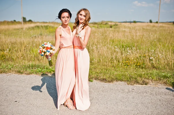 Twee bruidsmeisjes op rose jurken — Stockfoto